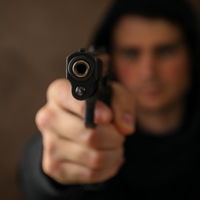 young man aiming a pistol