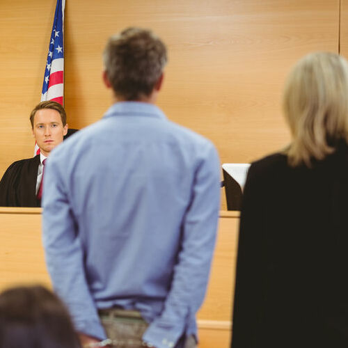 Accused Stands Before Judge on Bench Warrant.