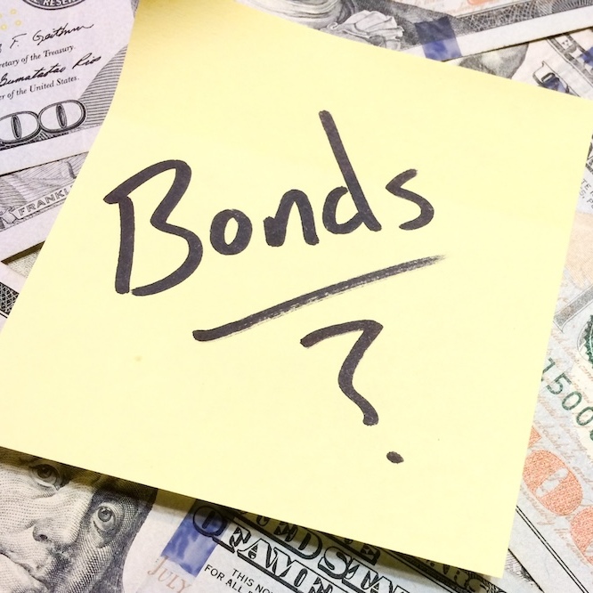 An image of money with a post-it of the word "Bonds?" written in Sharpie.